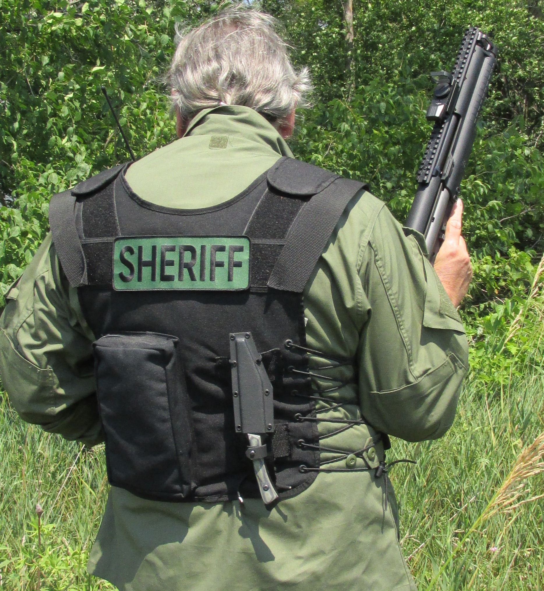 A sheriff wearing a vest that includes a Spectre Forge knife 